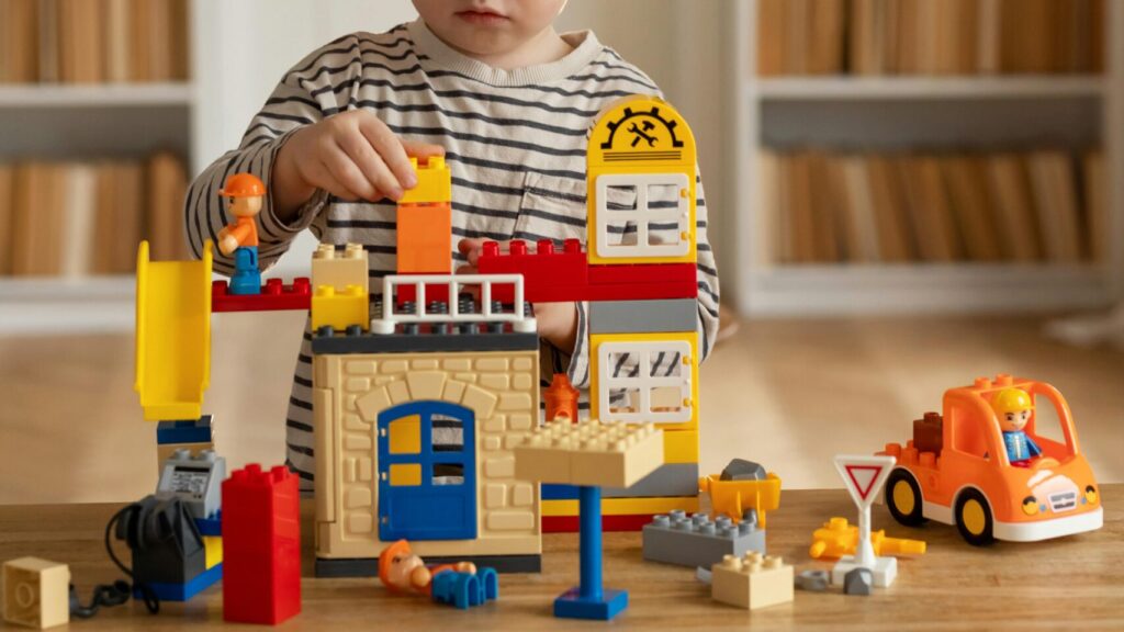 Image shows child playing with LEGO toys.