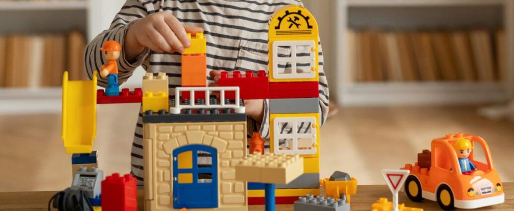 Image shows child playing with LEGO toys.