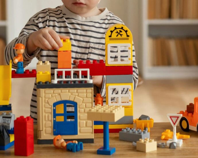 Image shows child playing with LEGO toys.