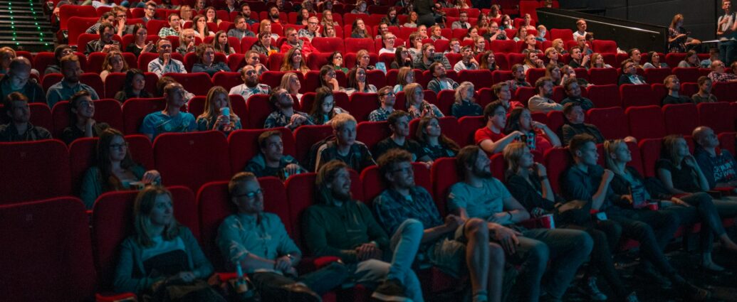 People sitting in a theatre watching a film.