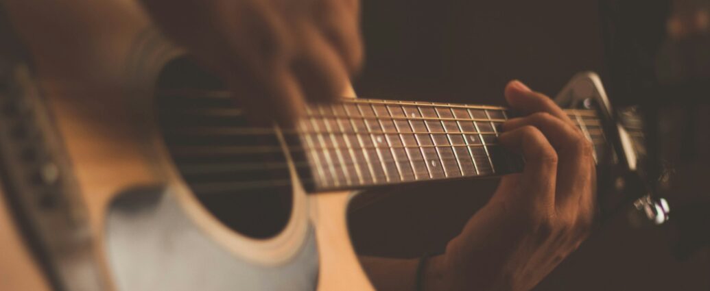 Individual playing the guitar. Representing A Complete Unknown