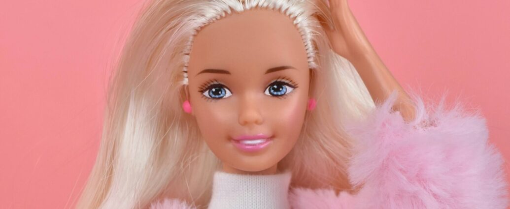 A blonde Barbie Doll wearing a pink jacket