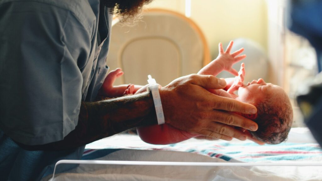 Image of a nurse lowering a baby onto a scale