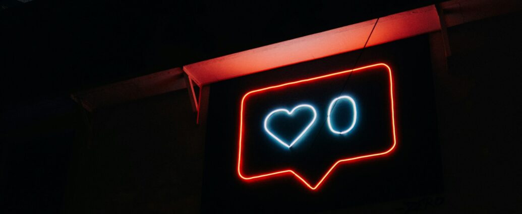 Neon sign depicting an outline of an Instagram 'like' social media symbol