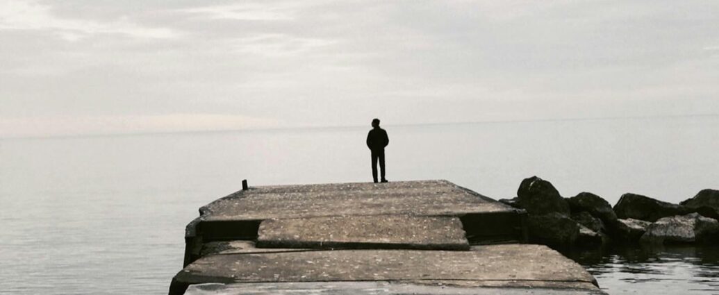 Silhouette of a man standing at a water's edge alone - can we combat extreme misogyny