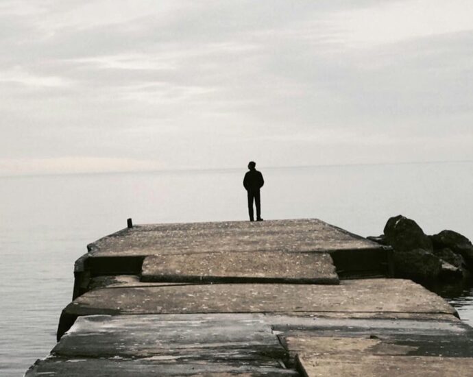 Silhouette of a man standing at a water's edge alone - can we combat extreme misogyny