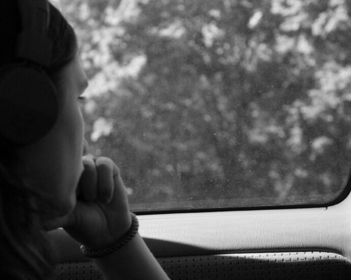 Woman with SAD looking out a car window at trees