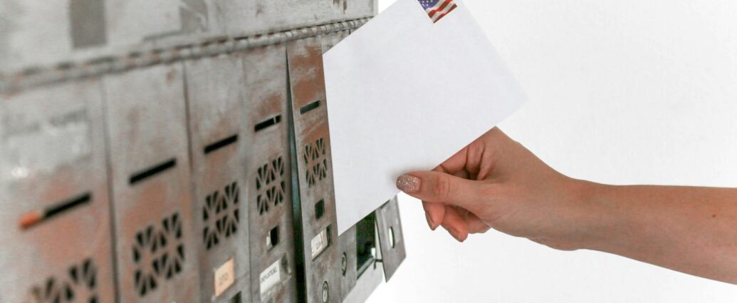 Person posting white envelope