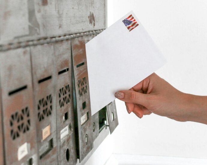 Person posting white envelope