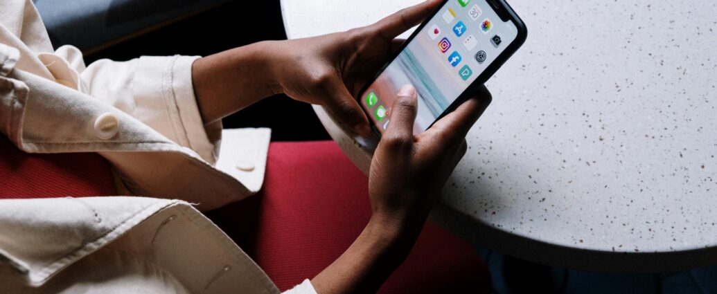 Person holding phone looking at social media apps