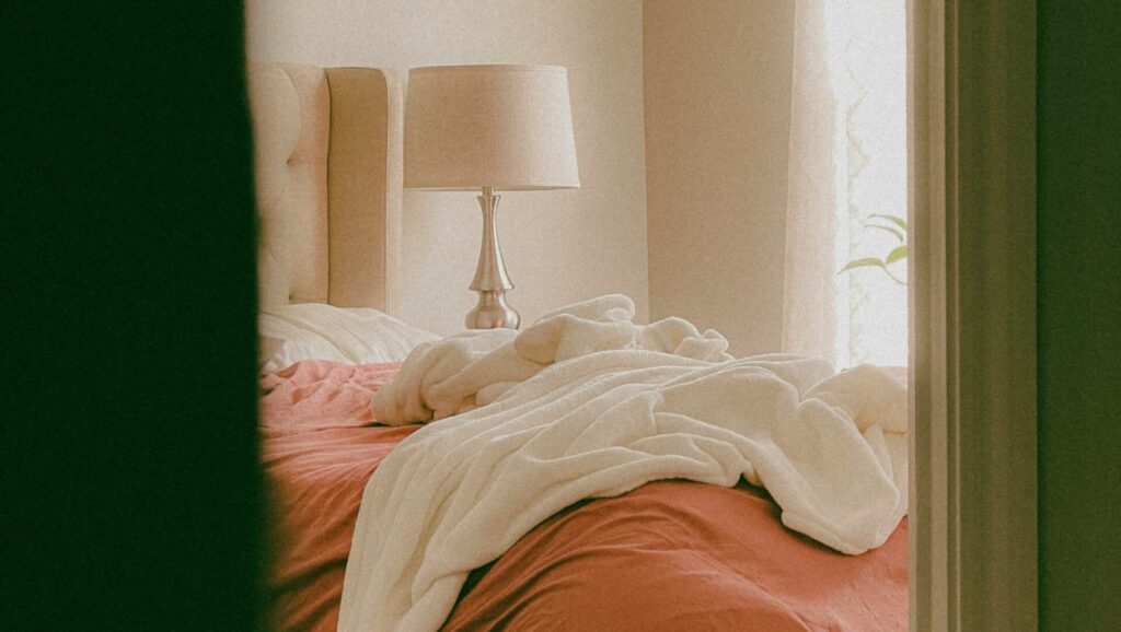 Perspective of peeking into a bedroom with a messy bed.