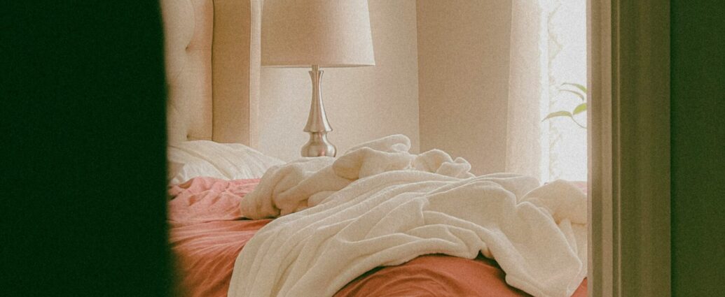 Perspective of peeking into a bedroom with a messy bed.